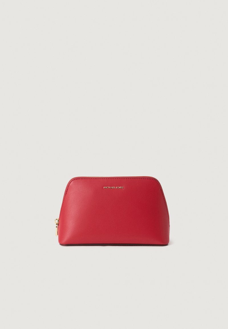 Sarkanā ādas kosmētikas somiņa ar noapaļotu formu, zelta tonēts rāvējslēdzis un uz priekšpuses izsistais "MICHAEL KORS" logotips. Gluda virsma.