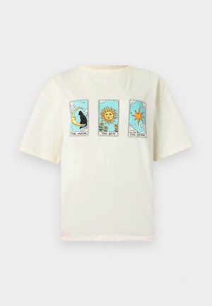 T-shirt crème avec trois motifs de cartes de tarot : un chat noir sur un croissant de lune, un soleil souriant avec des fleurs et une étoile à huit branches.
