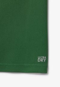 Țesătură verde, texturată, cu plasă respirabilă. Afișează "ULTRA DRY" în gri aproape de tiv. Design clasic de tricou sportiv.