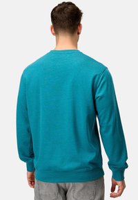 Turkis crewneck sweatshirt lavet af blødt materiale, med ribbede manchetter og kanten, glat tekstur og en afslappet pasform.