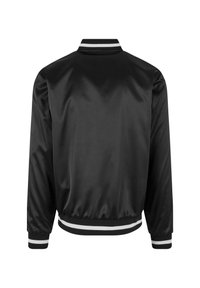 Veste bomber en satin noir avec col et poignets en ribbed à rayures blanches. Texture lisse, taille élastique et design de style classique.
