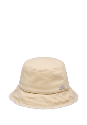 Chapeau seau en coton beige avec bord à bords bruts et petite étiquette rectangulaire de la marque sur le côté.