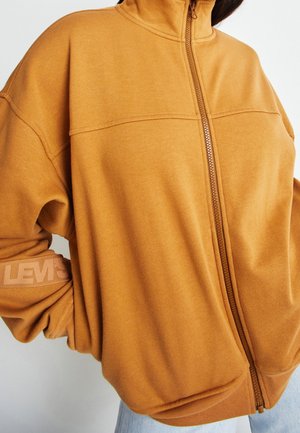 Felpa arancione con zip e colletto rialzato, polsini a coste e logo "Levi's" stampato chiaro sulla manica. Tessuto morbido e vestibilità comoda.