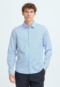 Cămașă butonat de culoare albastră deschisă, cu modele geometrice mici, mâneci lungi și guler clasic. Materialul pare neted și ușor.