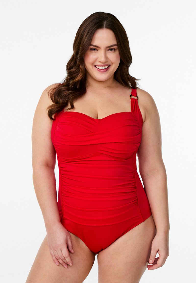 Maillot de bain rouge une pièce avec tissu froncé, larges bretelles avec un accent doré et décolleté en cœur. Texture lisse, couverture moyenne.