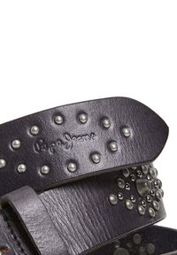 Schwarze Ledersandale mit metallicnietenbesetzten Riemen, die über eine strukturierte Oberfläche und ein geprägtes Logo verfügt. Auffällige runde, genietete Akzente.