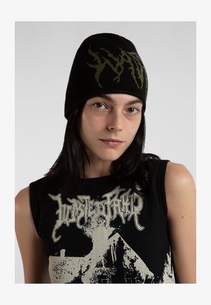 Gorro de punto negro con un diseño gráfico verde en la parte frontal. La textura es suave y se ajusta cómodamente en la cabeza.
