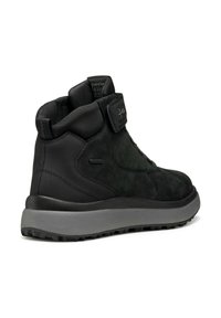 Botas impermeables negras con parte superior de ante y sintético, con una correa de Velcro, cuello acolchado y suela de goma texturizada.