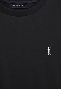 T-shirt noir à col rond avec un petit logo blanc Polo Club représentant une personne portant un maillet sur le côté gauche de la poitrine.