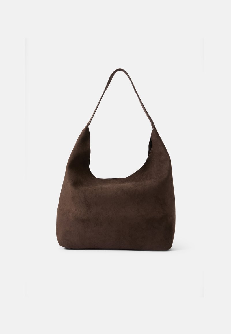 Sac hobo en daim marron avec une large ouverture et une seule longue sangle, présentant une finition douce et texturée ainsi qu'une forme minimaliste.