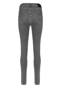 Chude szare dżinsy o wyblakłej fakturze, tylne kieszenie oraz czarna metka w pasie. Materiał dżinsowy ma gładkie wykończenie.