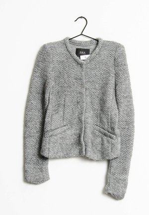 Grijze, gestructureerde, gebreide cardigan met lange mouwen, twee steekzakken aan de voorkant en een ronde halslijn, hangend aan een zwarte kledinghanger.