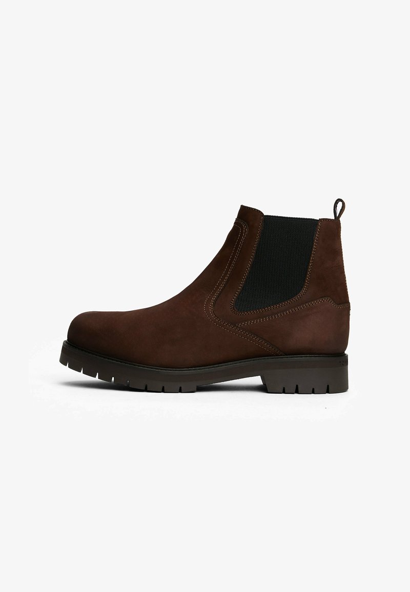 Braune Chelsea-Stiefel aus Leder mit schwarzen elastischen Seiteneinsätzen, Zuglasche an der Ferse und profiliertem Sohlen, im linken Profil vor weißem Hintergrund dargestellt.
