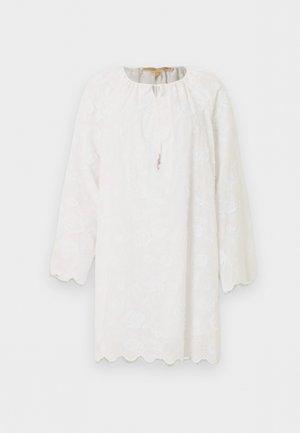 Robe tunique blanche à manches longues avec broderie florale, ourlet et poignets festonnés, et un col rond avec un lien à l'avant et des accents métalliques.