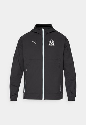 Black lightweight jacket with a hood, featuring a front zipper, white Puma logo, and Marseille design at chest, elastic cuffs, and side pockets.