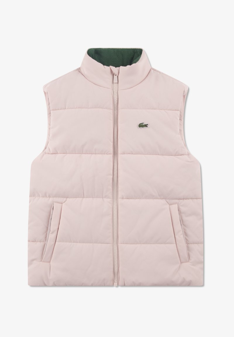 Ružová prešívaná vesta s vysokým golierom, zapínaním na zips a dvoma bočnými vreckami. Má zelenú vnútornú podšívku a malý zelený logo detail.