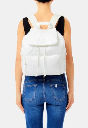 Zaino bianco in nylon con patta superiore, chiusura a cordoncino e tasca frontale. Spallacci imbottiti e maniglia superiore. Tessuto liscio e leggero.