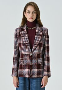 Blazer texturé avec un motif à carreaux bordeaux, bleu et crème. Doté d'un col cranté, d'un bouton à l'avant et de deux poches.