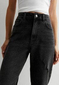 Hoge taille zwarte denim jeans met een verwerkte detail op de dij, klassiek vijf-pocket ontwerp en een knoopsluiting bij de taille.