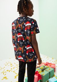 Kurzärmliges, marineblaues Hemd mit festlichem Druck von Spielcontrollern, Rentieren und Weihnachtselementen; weicher Stoff mit lockerem Schnitt.