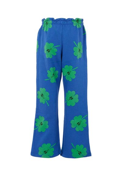 Pantalon bleu en tissu doux, doté de motifs de trèfle vert et d'une taille élastiquée avec des volants en haut. Design à jambe évasée.