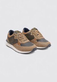 Zapatillas marrones que combinan materiales de gamuza y malla, con un interior azul marino, acentos texturizados y una media suela blanca.