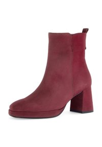 Burgundy suede ankle boot with a rounded toe, chunky heel, and a back pull tab. Smooth texture and stitching detail along the sides.