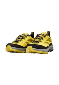 Scarpe da trekking gialle e nere con tomaia texturizzata, punta rinforzata e suola in gomma. Presentano lacci con pattern bianco e nero.