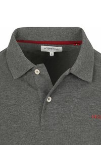 Grijze polo met een gestructureerde stof, voorzien van een placket met twee knopen, een klein rood logo op de borst en rode details aan de binnenkant van de kraag.