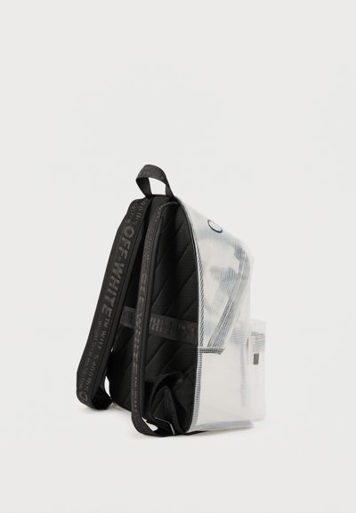 Διαφανές λευκό σακίδιο με μαύρη επένδυση στην πλάτη και τους ιμάντες, με το εμπορικό σήμα "OFF-WHITE" τυπωμένο στους ιμάντες και μια εμπρόσθια τσέπη.