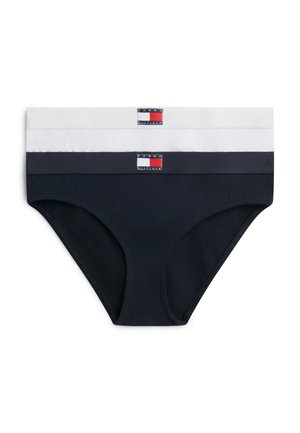 Δύο ζευγάρια γυναικεία μαγιό Tommy Hilfiger στοιβαγμένα, ένα λευκό και ένα ναυτικό μπλε, το καθένα με λογότυπο στην ελαστική ζώνη.