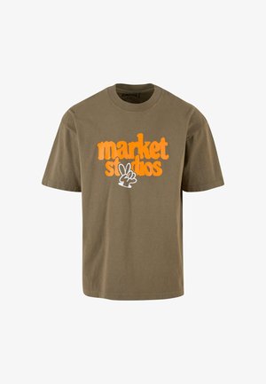 Alyvuogių spalvos medvilninis marškinėliai su dideliu oranžiniu ir baltu grafiniu užrašu "market studios" ir taikos ženklo dizainu apačioje.