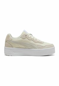 Baskets beige clair avec une tige en daim et en cuir, bout rond, semelle blanche plate et fermeture à lacets. Présente un design latéral légèrement incurvé.