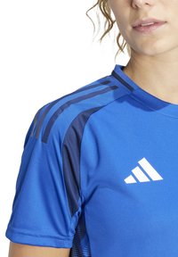 Blauw sportshirt met contrasterende donkerblauwe strepen op de schouders, ademend materiaal met meshpanelen en witte logodetail.