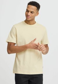 Beige bomulds t-shirt med rund hals, korte ærmer og lige snit. Minimalistisk design uden synlige mønstre eller accenter.