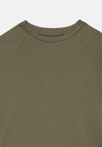 Λαδί πράσινο T-shirt με στρογγυλή λαιμόκοψη και μανίκια ράγκλαν, κατασκευασμένο από μαλακό, λείο ύφασμα με διακριτική υφή. Χωρίς σχέδια ή διακοσμητικά στοιχεία.