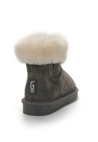 Stivale alla caviglia in suede grigio con un bordo in pelliccia sintetica bianca e suola in gomma. Include un'etichetta con il logo sul tallone con un dettaglio di cucitura.