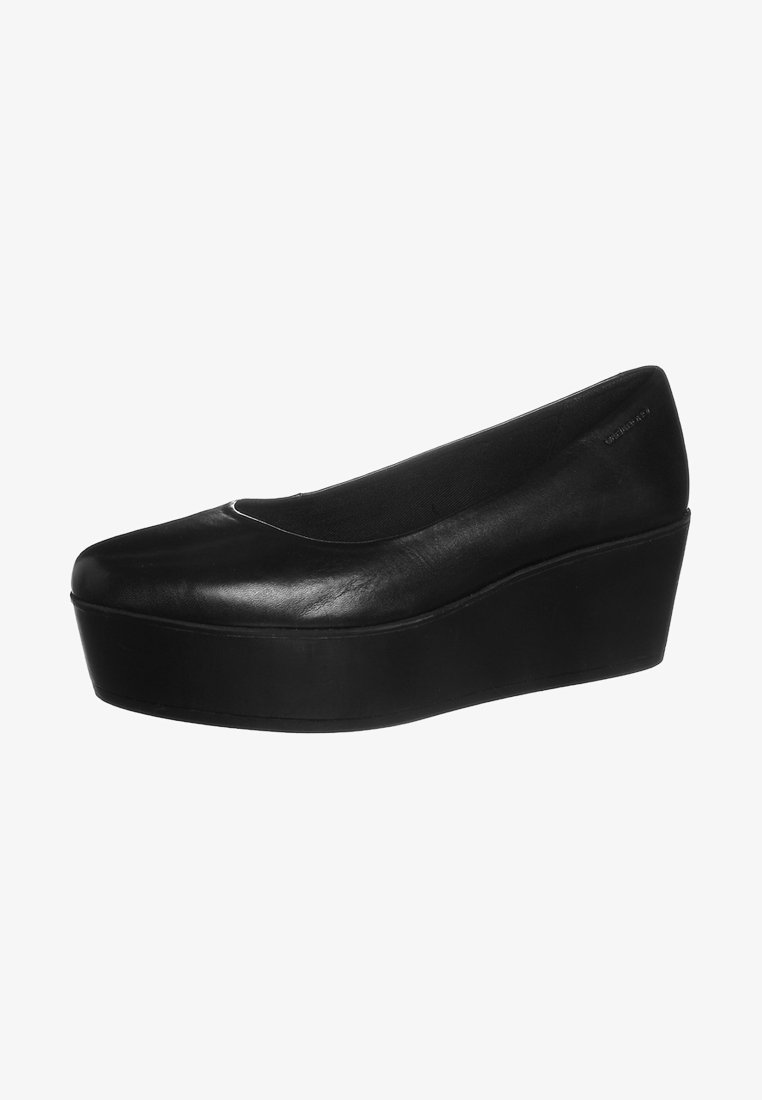 Chaussure compensée à plateforme en cuir noir avec bout fermé et côtés échancrés, dotée d'une semelle épaisse et de détails décoratifs minimaux.
