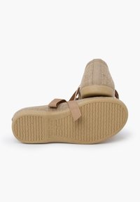 Chaussures en tissu beige avec des bandes élastiques, tige texturée et semelle en caoutchouc dotée d'un motif ondulé. Fabriquées en Espagne, avec marquage de taille.