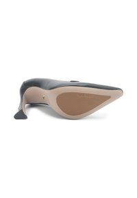 Black leather high-heeled shoe with a pointed toe, textured sole, and a beige insole. Brand logo "NINE WEST" embossed on the sole.