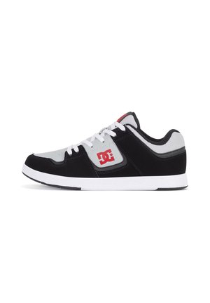 Basket basse noire et grise avec lacets et semelle blancs, avec un logo rouge DC sur le panneau latéral.