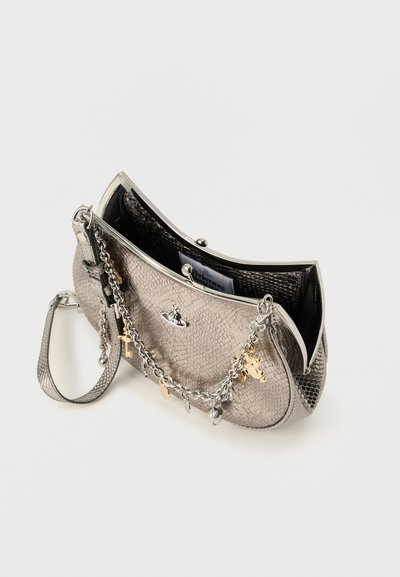 Μικρό μεταλλικό ασημένιο τσαντάκι χειρός με υφή φίδι, με αλυσίδα διακοσμημένη με χρυσές και ασημένιες γοητείες, ακουμπισμένο ανοιχτό σε λευκό φόντο.