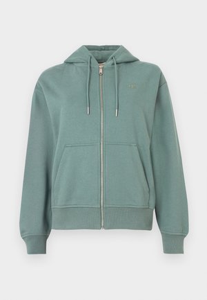 Heleroheline tõmblukuga dressipluus kapuutsiga, esiteljed, soonikkoes mansetid ja servad. Vasakul rinnal väike logo. Pehme materjal.