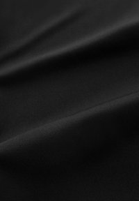 Tessuto nero con superficie liscia e una leggera lucentezza, caratterizzato da pieghe e grinze delicate. Il materiale sembra leggero e flessibile.