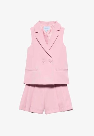 Blazer rosa doppiopetto senza maniche con revers a lancia abbinato a pantaloncini plissettati coordinati su sfondo bianco.