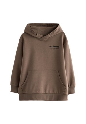 Persoon draagt een bruine hoodie en broek, met de rug naar de camera, met "ALLSAINTS", Japanse tekst en "LONDON" bedrukt op de achterkant van de hoodie.