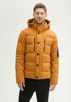 Oranje pufferjack met capuchon, voorzien van zwarte knopen en ritsen, horizontaal gestikt patroon en een ritszak op de mouw.