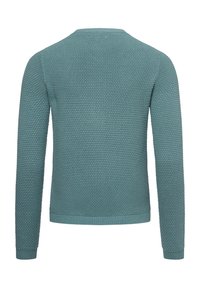 Stickad tröja i teal med en strukturerad mönstring. Har lång ärm och rund hals. Ribbad ärmslut och nederkant ger struktur.