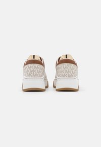 Sneakers bianchi con un tallone in pelle marrone chiaro, dettagli beige e un retro in tessuto a fantasia che presenta le lettere "MK" in beige.