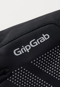 Schwarze Fahrradhandschuhe mit GripGrab-Logo. Das Material hat eine glatte Oberfläche, gepunktete Griffmuster und elastische Bündchen für eine enge Passform.